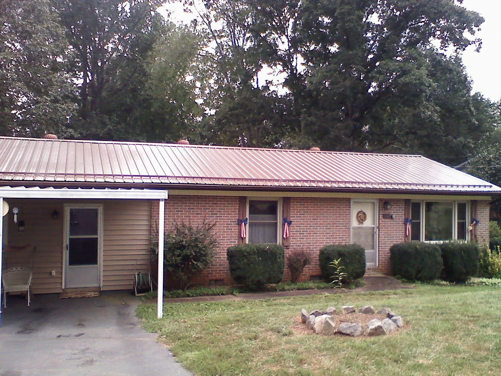 Bronze metal roof and carport on a brick ranch home — Roof Repair work by our crew in Water Mill